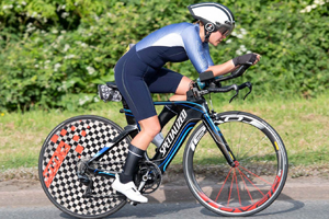 A woman cycling a time trial bike in a race
