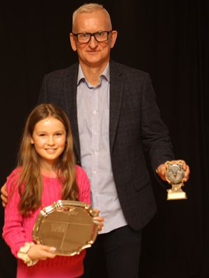 A man presenting a trophy to a girl