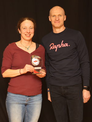 A woman receiving a trophy from a man