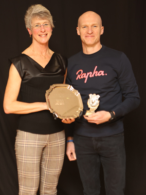 a woman receiving a trophy from a man